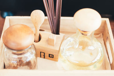 Close-up of glass jars in wooden tray