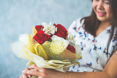 Midsection of woman holding flower bouquet