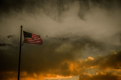 Low angle view of flag against cloudy sky