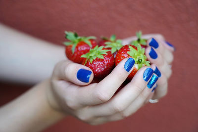 Close-up of hand holding strawberries