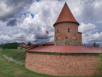 Traditional building on field against sky