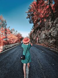 Rear view of woman walking on road