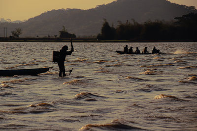 Silhouettes of fishermen against the sunset in lak lake. lien son, dak lak province, vietnam