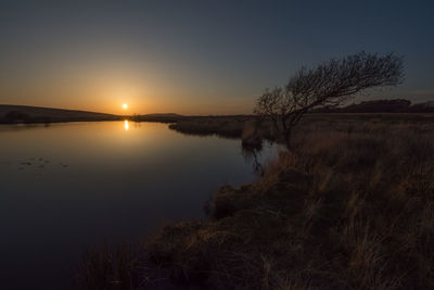 Scenic view of lake against sky during sunset