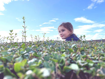 Portrait of young woman standing amidst plants