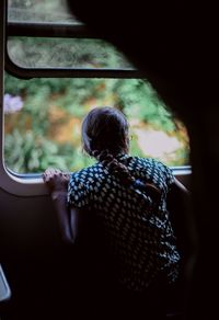Rear view of woman sitting in bus