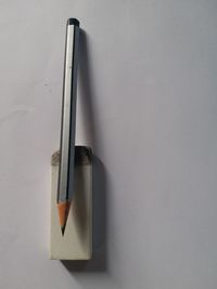 Close-up of pen on table against white background