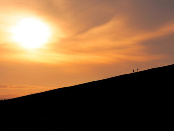 Silhouette landscape against sky during sunset