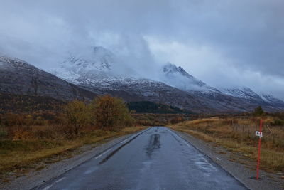 Road leading towards mountain against sky