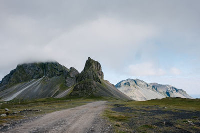 Road leading towards mountain against sky