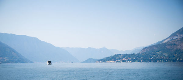 Scenic view of sea and mountains against clear sky