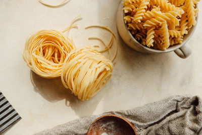 Raw tortiglioni pasta on background in cup. process of making hand-made pasta from durum wheat