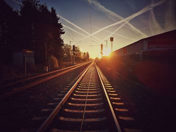 Railroad tracks against sky during sunset