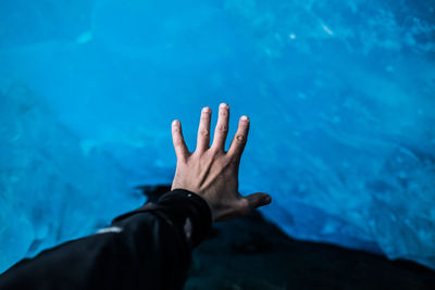 Midsection of person hand in swimming pool