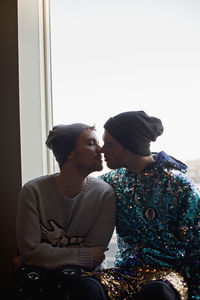 Young men kissing in a window