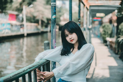 Portrait of young woman looking at railing