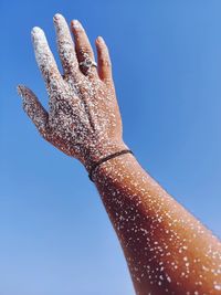 Close-up of painted hand against clear blue sky