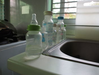 Close-up of empty baby bottles on counter at home