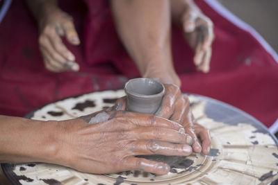 Close-up of hands making pottery