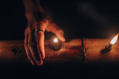 Close-up of hand holding burning candle