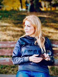 Portrait of young woman looking away while sitting outdoors