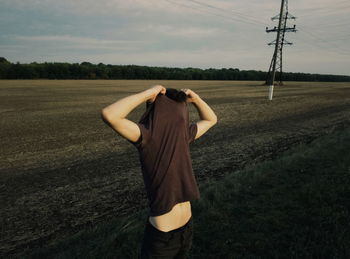 Rear view of woman standing on field