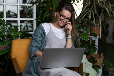 Woman using laptop while sitting on chair