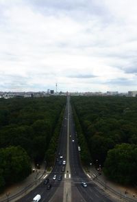 Aerial view of vehicles moving on highway against cloudy sky