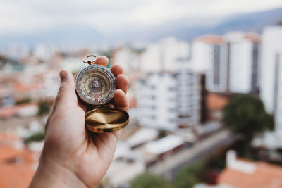 One hand holding a compass