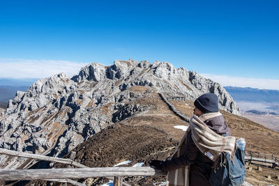 Midsection of man on rock against sky