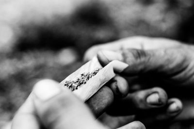 Close-up of hand holding cigarette