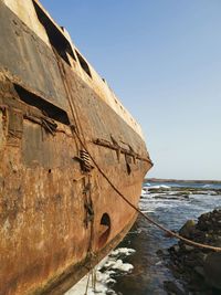 Old boat on beach against clear sky