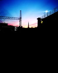 Low angle view of silhouette buildings against clear sky