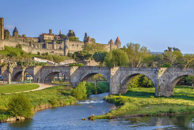 Arch bridge over river against sky