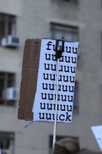 Close-up of cardboard in monopod against building