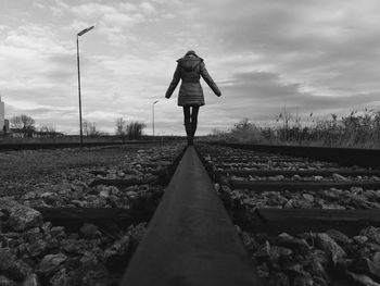 Man standing on railroad track against sky