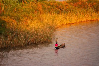 A tourist riding a traditional canoe at lake mutanda in kisoro town, uganda