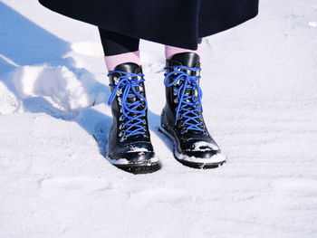 Low section of person standing on snow