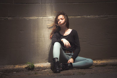 Portrait of young woman sitting on floor