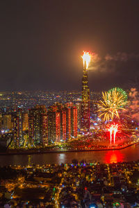 Firework display over city lit up at night