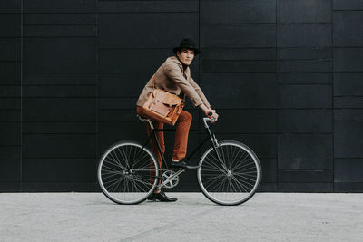 Man riding bicycle against wall