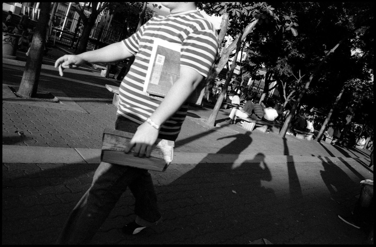 lifestyles, full length, leisure activity, men, casual clothing, low section, walking, person, shadow, transfer print, rear view, tree, auto post production filter, sunlight, standing, childhood