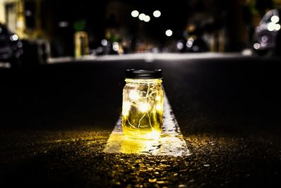 Close-up of glass bottle on table at night