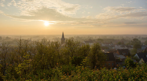 Scenic view of townscape against sky at sunset