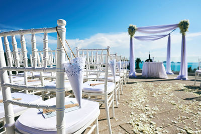 Empty chairs and tables against blue sky