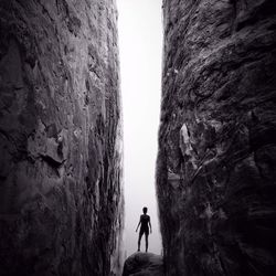 Rear view of person standing between two rocks