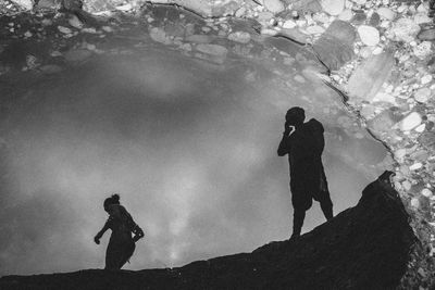 High angle view of man and woman reflecting in puddle