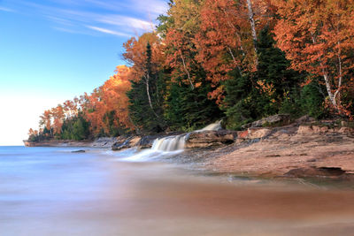 Scenic view of stream by sea against sky