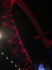 Low angle view of illuminated ferris wheel against sky at night