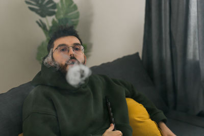 Portrait of young man smoking cigarette